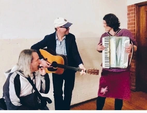CUSP facilitators making music together — guitar, accordion and harmonica